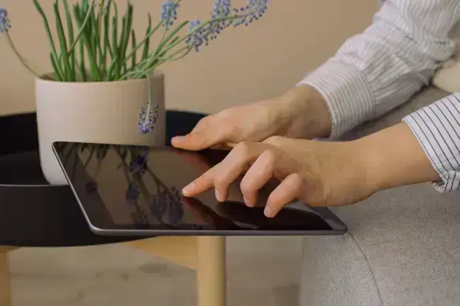 Mains d'une femme faisant des recherches sur sa tablette