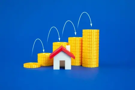 Une maison et une pile de pièces qui poussent comme un graphique. Hausse des prix de l'immobilier. Hausse des coûts