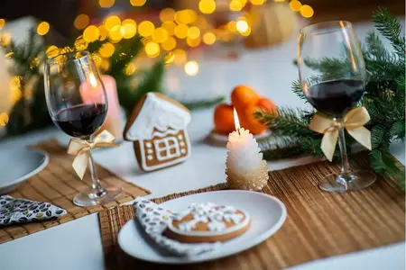 Deux verres à vin rouge sur la table de Noël, bougies, fond festif