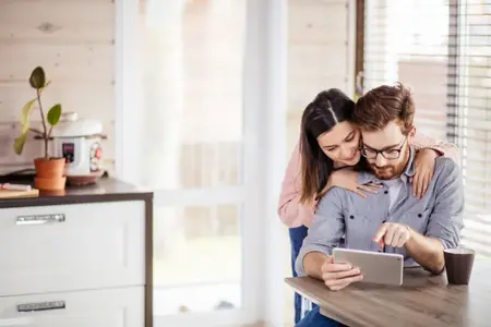 Couple affectueux utilisant une tablette ensemble à l'intérieur