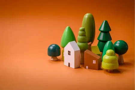 Ville miniature en bois et arbres sur fond orange