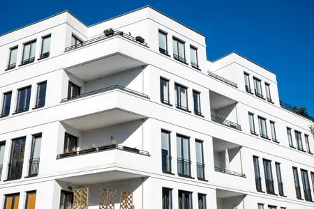 Immeuble d'appartements blanc moderne se détachant sur un ciel bleu éclatant