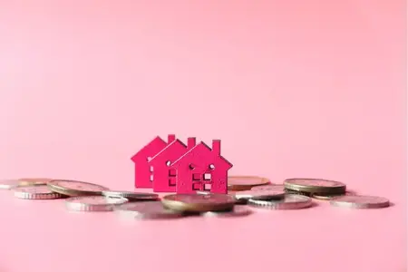maisons en bois colorées sur fond rose, le concept de financement