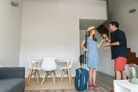 Une femme souriante reçoit les clés d'un homme dans son appartement