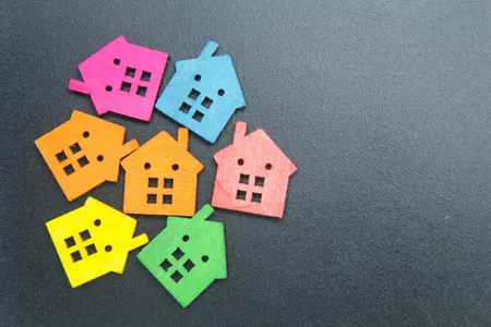 une petite maison en bois colorée avec un concept immobilier ou hypothécaire avec un espace de copie sur le côté