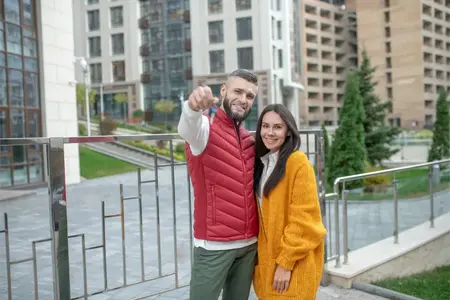 Couple tenant des clés en extérieur dans un cadre urbain