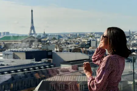 Une femme sourit avec la tour Eiffel en arrière-plan