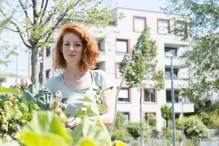 Jeune femme cultivant un jardin en milieu urbain