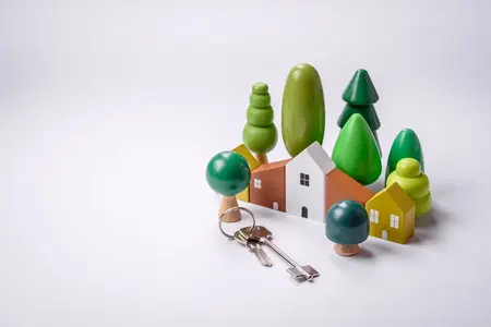 Une petite maison en bois et des clés comme idée pour investir dans votre propre maison