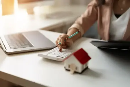 Main d'une femme calculette maison