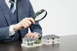 Homme d'affaires inspectant une maison avec une loupe